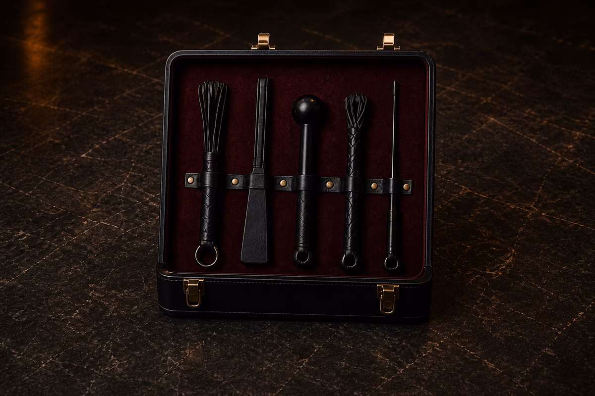 Small open black presentation case containing five refined black impact implements arranged in burgundy lining
